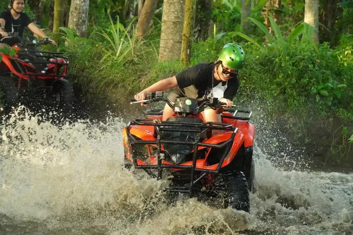 Rider crossing shallow water on an ATV