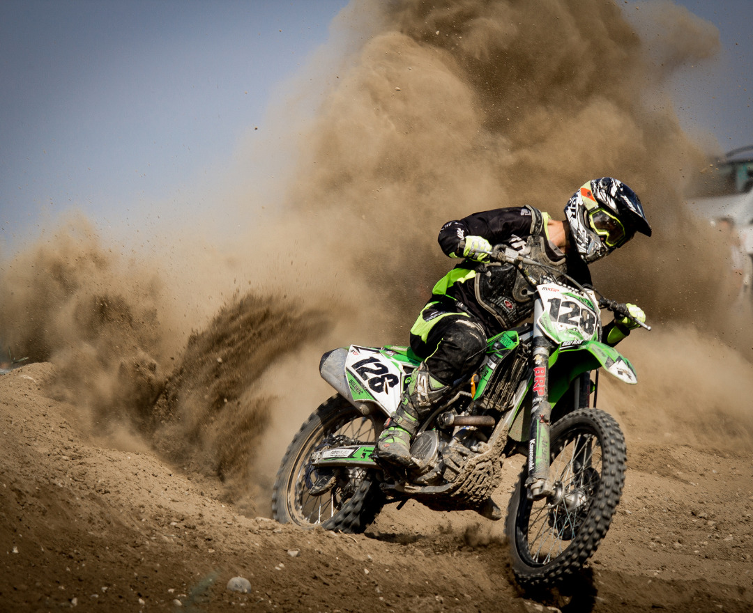 Rider on a dirt bike along a dusty trail