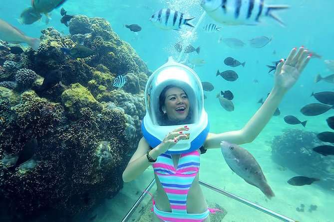 Sea walker wearing an underwater helmet among fish