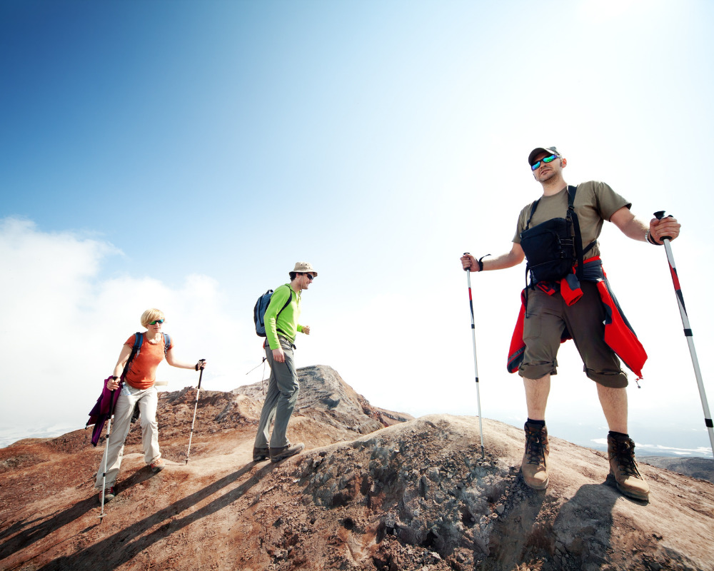 Hikers walking across a rocky mountain landscape