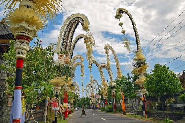 Decorated penjor lining a Balinese road for Galungan