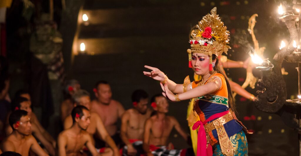 Balinese Kecak dance performer surrounded by seated dancers